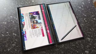 ASUS Zenbook Duo (2024) UX8406 flat on a marble countertop demonstrating sharing mode